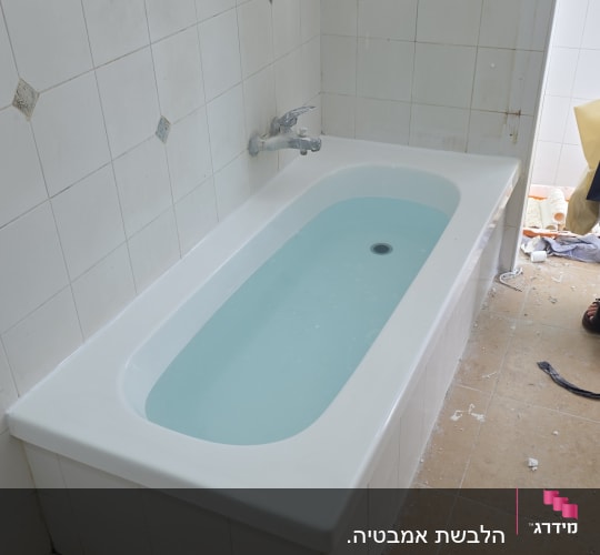 אמבטיה עם אריחים לבנים ועבודת שיפוץ